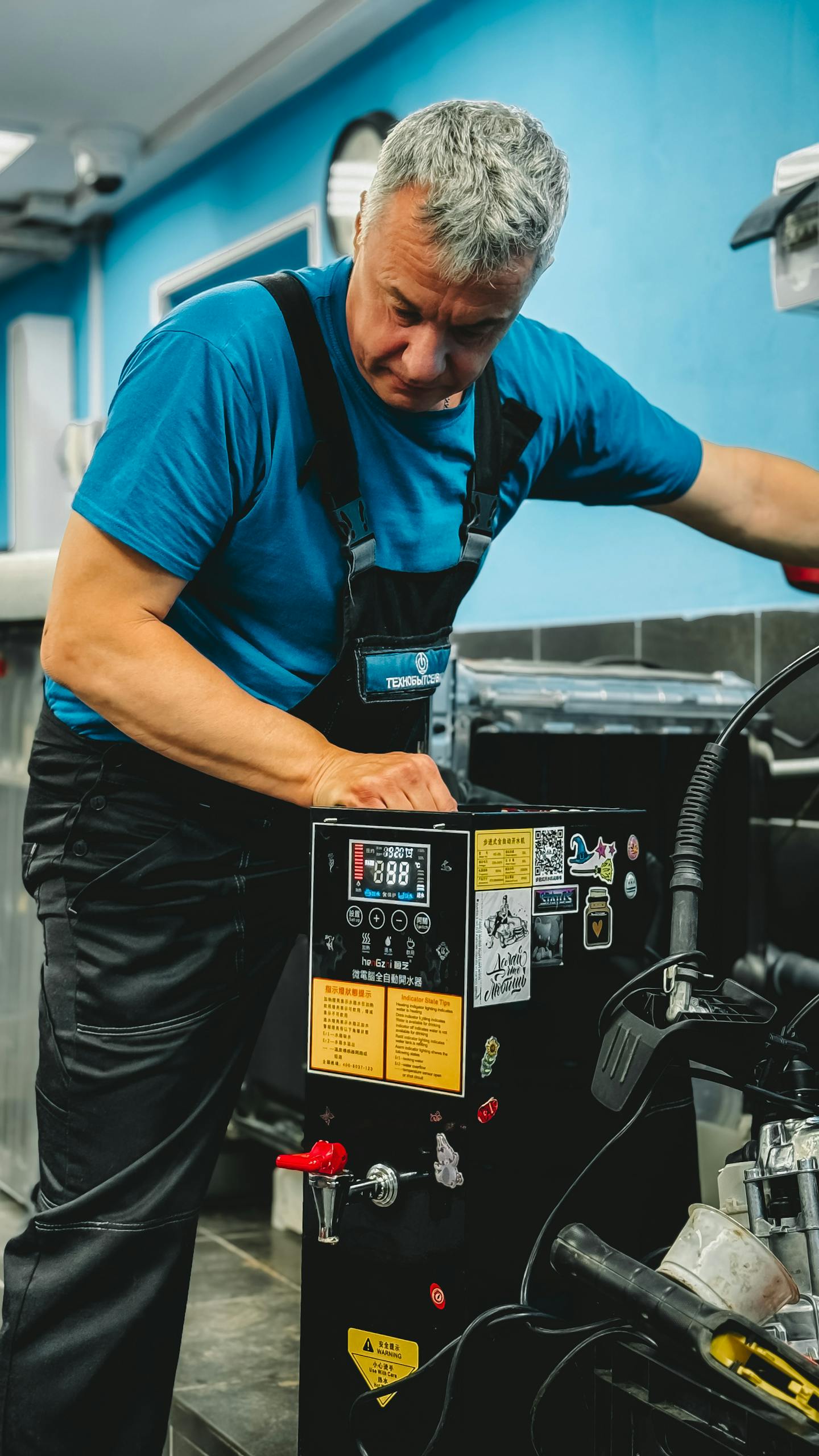 Mechanic working with machinery in a workshop, focused and skilled.